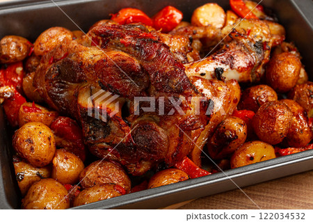 Pork knuckle, baked with vegetables, new potatoes , on a baking sheet, homemade, no people, Pork knuckle, baked with vegetables, new potatoes , on a baking sheet, homemade, no people, 122034532