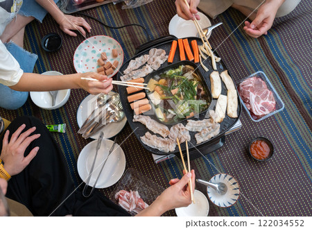 People enjoying their party with Korean BBQ and Shabu Shabu dinner. Korean BBQ is the popular method of grilling meat right at the dining table. 122034552