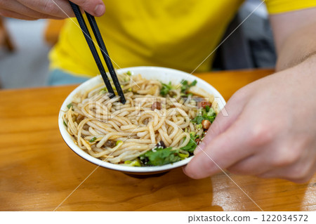 Enjoy a Delicious Bowl of Spicy Noodle Salad, Complete with a Variety of Toppings Enjoy a Delicious Bowl of Spicy Noodle Salad, Complete with a Variety of Toppings 122034572