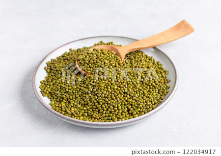 Dried mung beans in a ceramic plate on gray table 122034917
