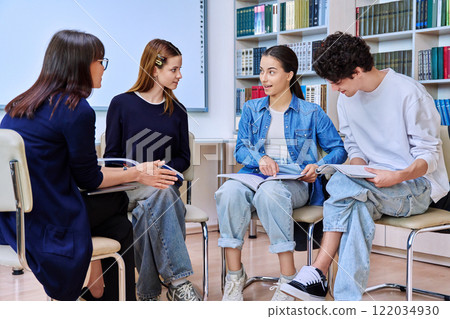 Group of teenage students with female teacher counselor inside classroom library Group of teenage students with female teacher counselor inside classroom library 122034930
