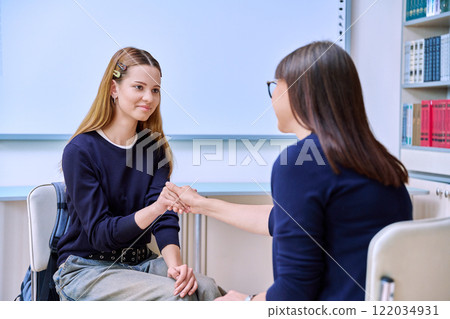Teenage student girl talking with female social worker, school counselor, teacher Teenage student girl talking with female social worker, school counselor, teacher 122034931