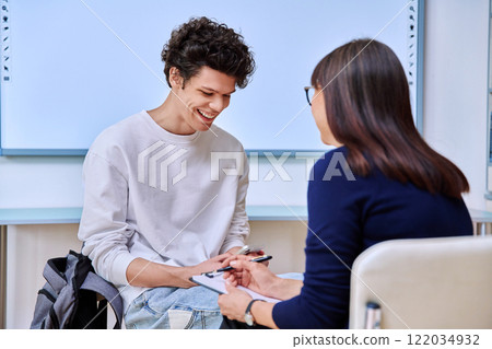 Psychologist working with young male college student in educational office 122034932