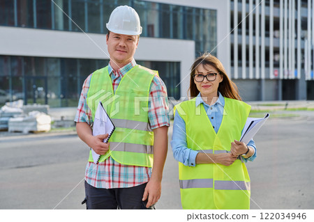 Two industrial workers looking at camera, outdoors on construction site Two industrial workers looking at camera, outdoors on construction site 122034946