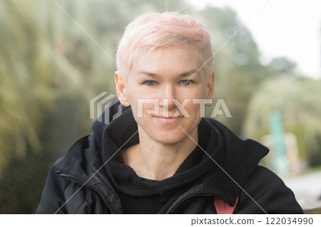 Attractive middle-aged woman with short hair and a black jacket outdoors 122034990