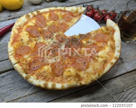 delicious slice of pizza lies on the table on a sliced board. 122035107