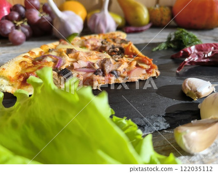 delicious slice of pizza lies on the table on a sliced board. 122035112