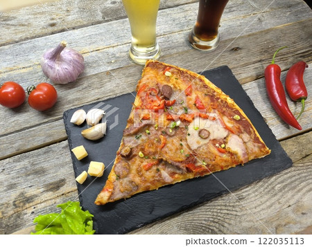 delicious slice of pizza lies on the table on a sliced board. 122035113