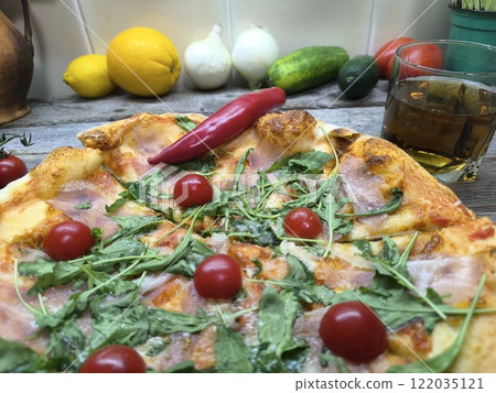 delicious slice of pizza lies on a sliced board, with glasses of beer in th.. 122035121