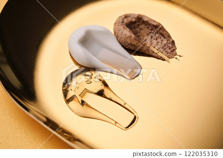Textures of different cosmetic products on a gold background. Textures of different cosmetic products on a gold background. 122035310