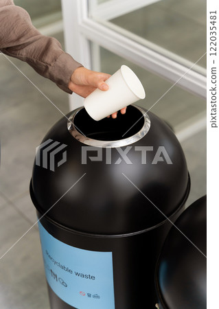 Woman choosing a proper container for throwing paper cup 122035481
