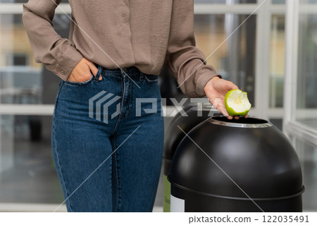 Woman in jeans throwing organic waste to the proper container 122035491