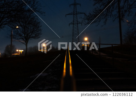 The steps are up, the railing is illuminated by an orange street lamp. Evening 122036112