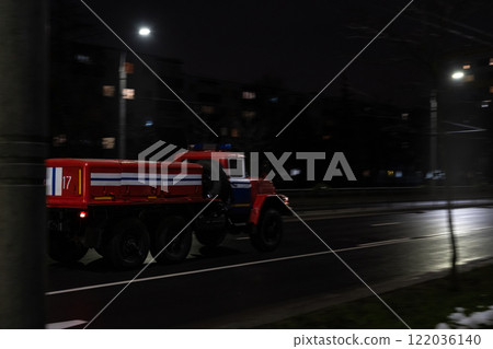 An old fire truck driving through the city at night, side view. Motion blur 122036140