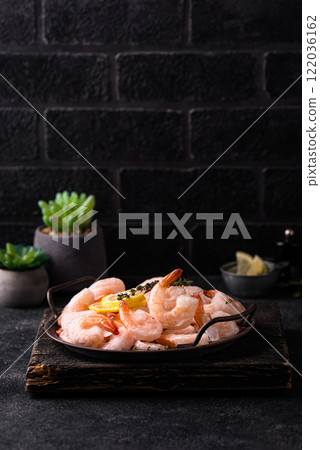 Frozen uncooked prawns or shrimps with lemon Frozen uncooked prawns or shrimps with lemon 122036162