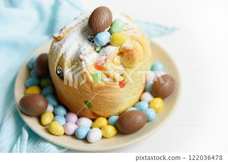 Traditional cupcake Easter cake kraffin with raisins on white background. choco eggs. Close up of homemade cake. Cruffin with candied fruits. Food. Copy space. 122036478