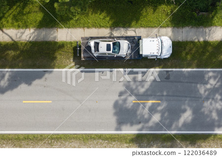 Tow truck loading crashed car on accident site. Emergency services personnel and vehicles responding to vehicle crash on American street. First responders helping on road in the USA 122036489