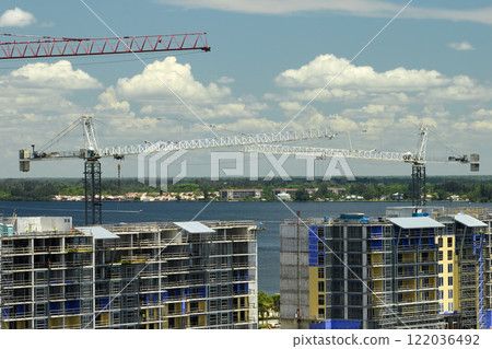 Tower lifting cranes at high residential apartment buildings construction site. Real estate development Tower lifting cranes at high residential apartment buildings construction site. Real estate development 122036492
