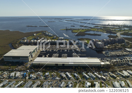 Warehouse with motorboats and yachts destroyed by hurricane winds in Florida coastal area. Natural disaster and its consequences Warehouse with motorboats and yachts destroyed by hurricane winds in Florida coastal area. Natural disaster and its consequences 122036525