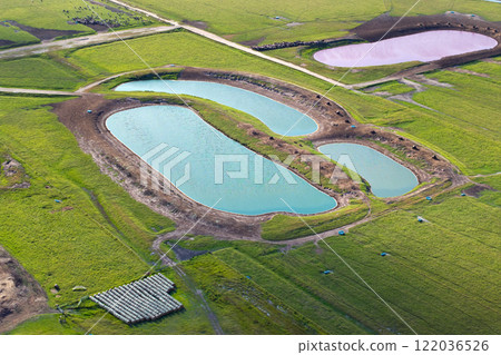 Water ponds for farm cattle. Drink source for cows grazing in pasture fields. Green industrial farm grassland in Florida 122036526