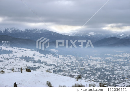 Winter landscape with small village houses between snow covered forest in cold mountains Winter landscape with small village houses between snow covered forest in cold mountains 122036551