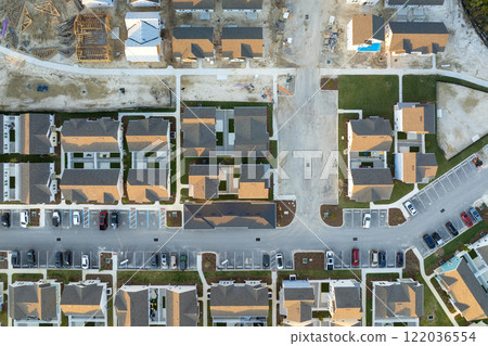 Wooden frames of new cheap American homes under construction. Development of residential housing in the USA Wooden frames of new cheap American homes under construction. Development of residential housing in the USA 122036554
