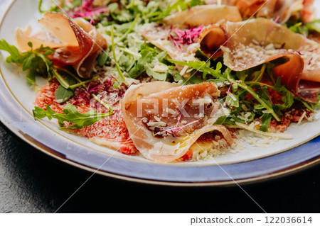 Gourmet salad with prosciutto, arugula, figs, and parmesan, a perfect fusion of flavors 122036614