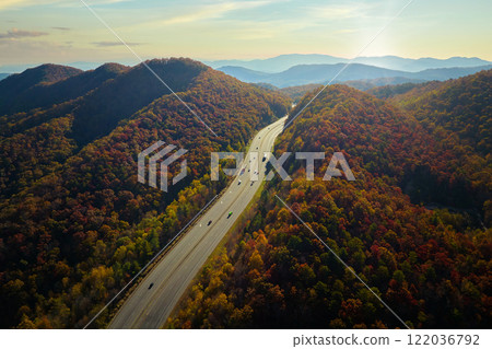 I-40 freeway road leading to Asheville in North Carolina thru Appalachian mountains with yellow fall forest and fast moving trucks and cars. Concept of high speed interstate transportation I-40 freeway road leading to Asheville in North Carolina thru Appalachian mountains with yellow fall forest and fast moving trucks and cars. Concept of high speed interstate transportation 122036792