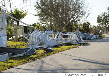 Metallic scrap rubbish on roadside from hurricane severely damaged houses in Florida residential area. Aftermath of natural disaster 122036814