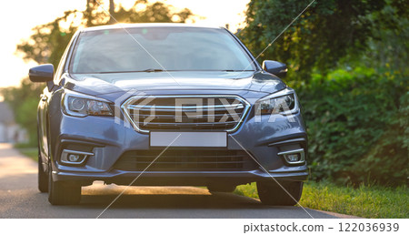 Front view of new shiny expensive car parked on city street side in evening. Front view of new shiny expensive car parked on city street side in evening. 122036939