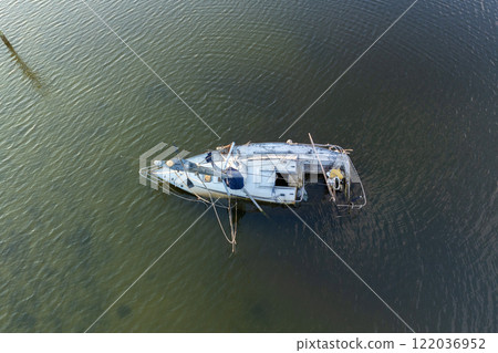 Half sunken sailing yacht capsized on shallow bay waters after hurricane Ian in Manasota, Florida Half sunken sailing yacht capsized on shallow bay waters after hurricane Ian in Manasota, Florida 122036952