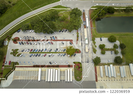 High angle view of big commercial shipping center with many freight trucks unloading and uploading goods for further distribution. Global economy concept High angle view of big commercial shipping center with many freight trucks unloading and uploading goods for further distribution. Global economy concept 122036959