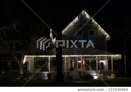 House front yard with big porch brightly illuminated with christmas decorations. Outside decor of florida family home for winter holidays House front yard with big porch brightly illuminated with christmas decorations. Outside decor of florida family home for winter holidays 122036968