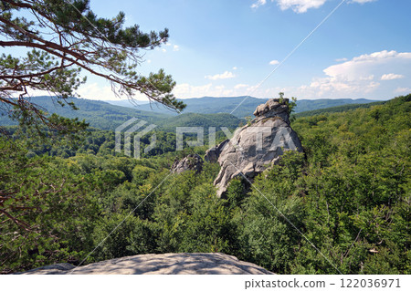 Huge rocky boulder formations high in mountains with growing trees on summer sunny day Huge rocky boulder formations high in mountains with growing trees on summer sunny day 122036971