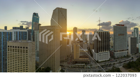 Evening urban landscape of downtown district of Miami Brickell in Florida USA. Skyline with dark high skyscraper buildings and street with cars and Metrorail traffic in modern american megapolis Evening urban landscape of downtown district of Miami Brickell in Florida USA. Skyline with dark high skyscraper buildings and street with cars and Metrorail traffic in modern american megapolis 122037093