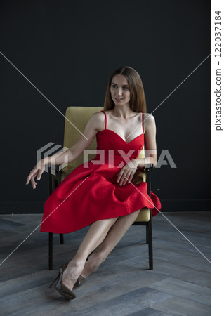 portrait of a beautiful young woman in a red dress, studio shot on a dark background portrait of a beautiful young woman in a red dress, studio shot on a dark background 122037184
