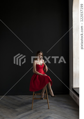 portrait of a beautiful young woman in a red dress, studio shot on a dark background portrait of a beautiful young woman in a red dress, studio shot on a dark background 122037199