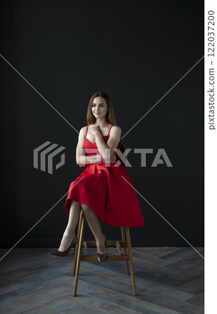 portrait of a beautiful young woman in a red dress, studio shot on a dark background portrait of a beautiful young woman in a red dress, studio shot on a dark background 122037200