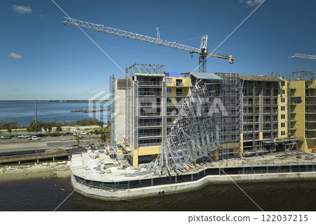Aerial view of ruined by hurricane Ian construction scaffolding on high apartment building site in Port Charlotte, USA 122037215