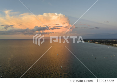 Aerial view of small yachts at sunset floating on sea waves with ripple surface. Motor boats recreation on ocean surface Aerial view of small yachts at sunset floating on sea waves with ripple surface. Motor boats recreation on ocean surface 122037226