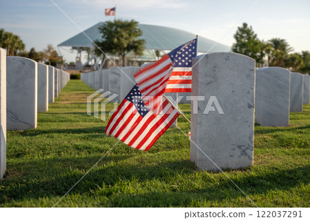American army national cemetery with rows of white headstones and USA flag on green grass lawn. Memorial Day concept American army national cemetery with rows of white headstones and USA flag on green grass lawn. Memorial Day concept 122037291
