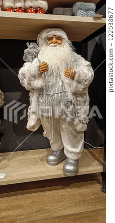 Santa Claus doll in white clothes. Decorative New Year's decoration in the form of a model of Santa Claus with a bag and a lamp in his hands. Santa Claus doll in white clothes. Decorative New Year's decoration in the form of a model of Santa Claus with a bag and a lamp in his hands. 122038677