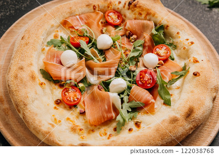 Gourmet pizza with prosciutto, mozzarella, arugula, and cherry tomatoes, food lover's feast Gourmet pizza with prosciutto, mozzarella, arugula, and cherry tomatoes, food lover's feast 122038768