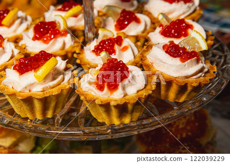 Indulge in these delicious tartlets filled with cream and topped with exquisite red caviar 122039229