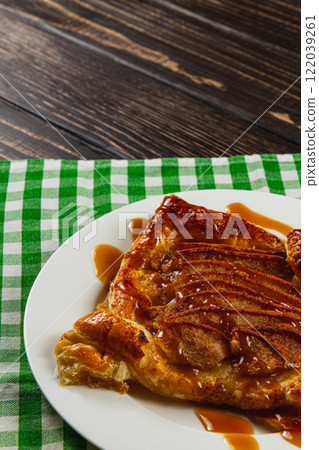 Delicious pastry dessert drizzled with caramel on a checkered tablecloth Delicious pastry dessert drizzled with caramel on a checkered tablecloth 122039261