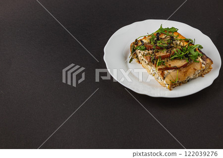 Gingerbread heart with red ribbon on wooden background for festive display 122039276