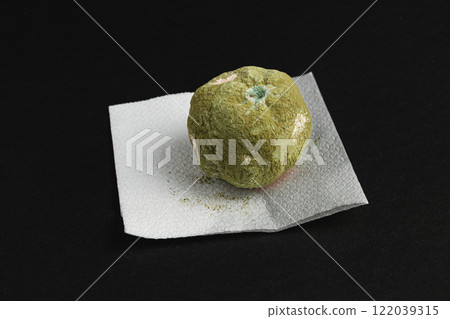 A moldy tangerineresting on a paper towel, showcasing the effects of decay and bacteria 122039315