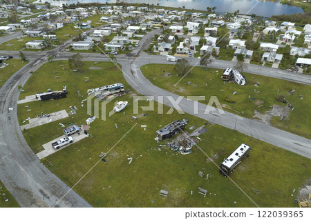 Severely damaged and overturned recreational vehicle camper vans and houses after hurricane in Florida mobile home residential area. Consequences of natural disaster 122039365