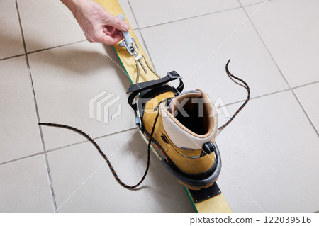 Wooden ski with universal cable Kandahar spring binding during installation. 122039516