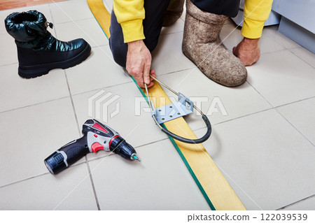 Skier installs spring cable bindings on wooden skis. 122039539